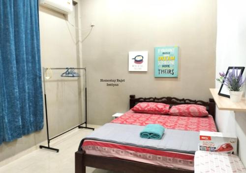 a bedroom with a bed and a blue curtain at Homestay Bajet Imtiyaz, Terengganu in Bukit Payong
