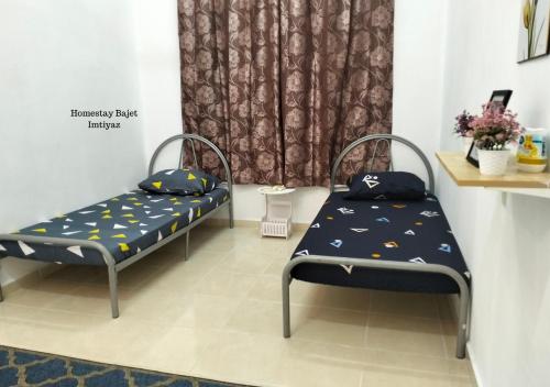 um quarto com duas camas e uma cortina em Homestay Bajet Imtiyaz, Terengganu em Bukit Payong