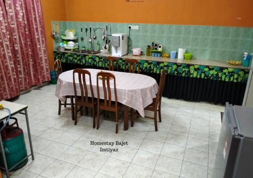 a kitchen with a table and chairs and a counter at Homestay Bajet Imtiyaz, Terengganu in Bukit Payong