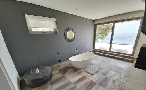 een badkamer met een wit bad en een groot raam bij The Llandudno in Llandudno