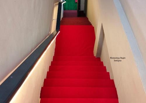 a red carpeted staircase in a building with a red floor at Homestay Bajet Imtiyaz, Terengganu in Bukit Payong