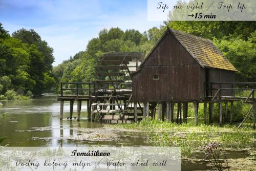 an old barn sitting next to a river at Rivapark in Dunajská Streda