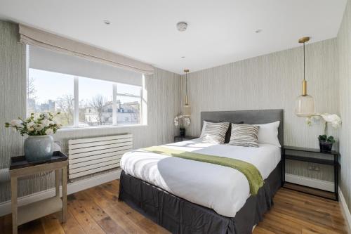 Luxury 3 Bedrooms Apartment in Central London في لندن: غرفة نوم بسرير كبير ونافذة