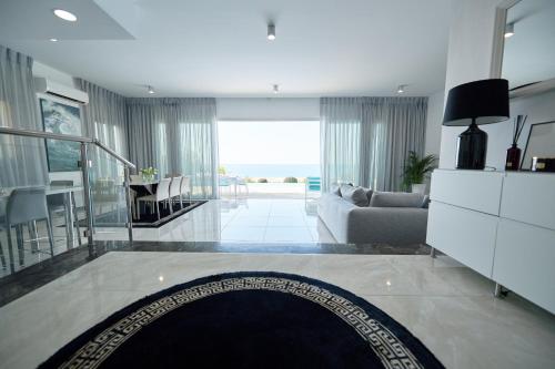 a living room with a couch and a table at Olymp Luxury Villa C in Kissonerga