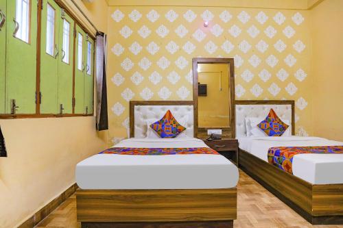 two beds in a room with two beds sidx sidx sidx sidx at FabHotel Shivam Palace in Varanasi