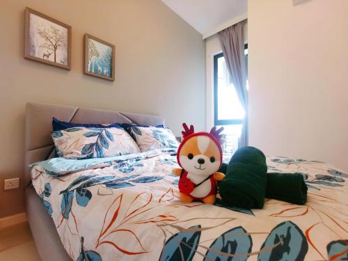 a stuffed animal sitting on a bed in a bedroom at Legoland - HappyWonder Suite for Family ,Cozy, Wifi with Nice Garden Pool View! in Nusajaya