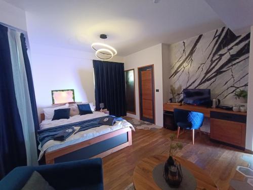 a bedroom with a bed and a desk and a chair at Square Luxury Apartments in Berovo