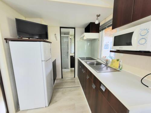 a kitchen with a white refrigerator and a sink at Camping Gran Sol in Montferrer