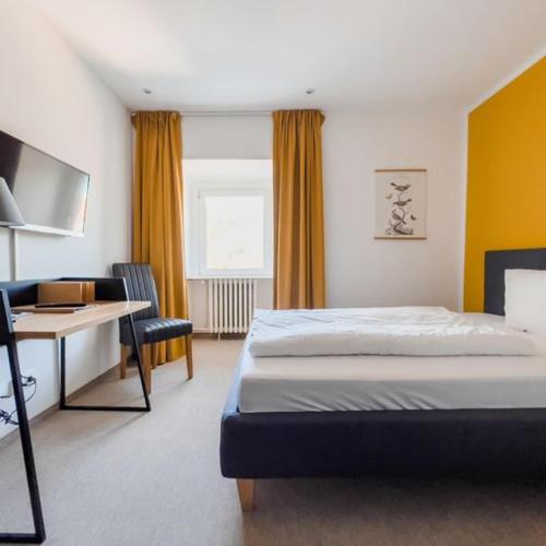 a bedroom with a bed and a desk and a computer at Hotel Trabener Hof in Traben-Trarbach
