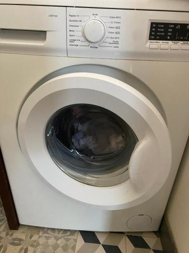a white washing machine with its door open at Casa Chiquinha in Ribeira da Prata