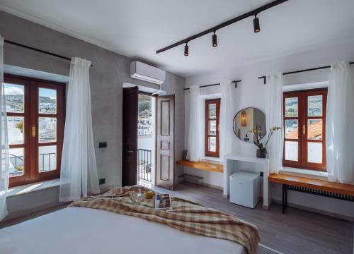 a bedroom with a large white bed and windows at Kilistra Lindian Living in Lindos