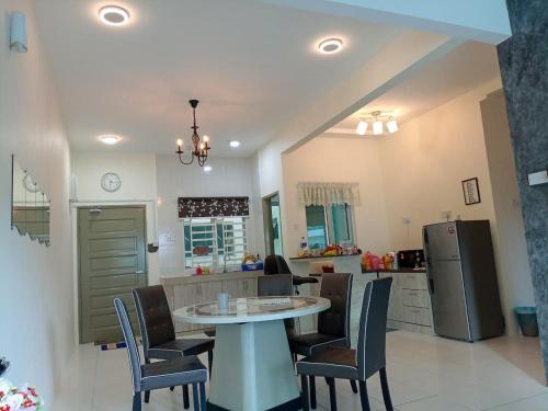 a kitchen and dining room with a table and chairs at Family Stay at Quintet A2-7-3A in Tanah Rata
