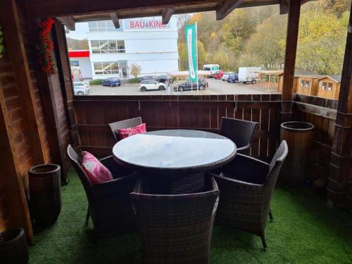 a table and chairs on a patio with a view of a parking lot at Ferienwohnung-lenne-Finnentrop in Finnentrop