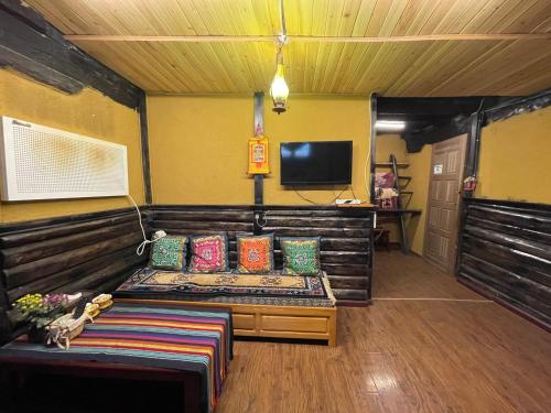 a living room with a couch and a tv at Timeless Inn in Shangri-La
