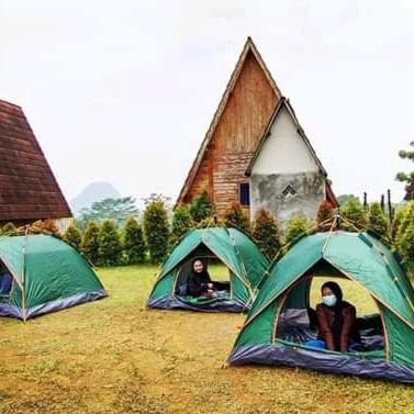 three people are sitting inside tents in a field at Monthong twbm Rumpin in Sawah