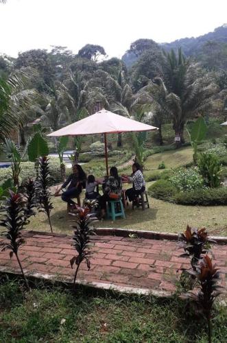 a group of people sitting under an umbrella at Monthong twbm Rumpin in Sawah