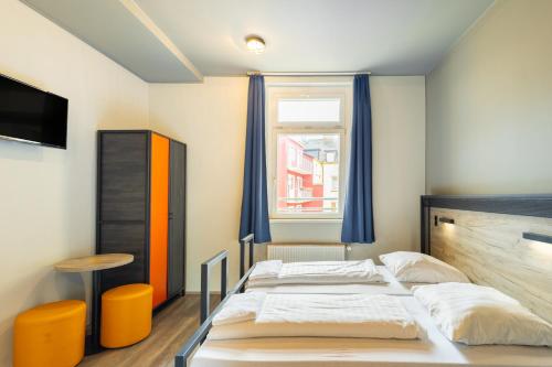 a bedroom with two beds and a window at a&o Dortmund Hauptbahnhof in Dortmund
