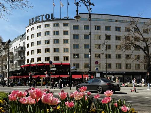 a building with a bunch of pink flowers in front of it at Hotel Bristol Berlin in Berlin