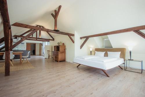 a bedroom with a white bed in a room with wooden floors at Hotel Trabener Hof in Traben-Trarbach