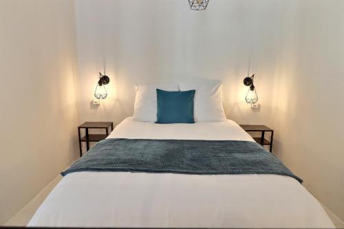 a bedroom with a white bed with a blue pillow at P&R1, one bedroom, city center Geneva in Geneva