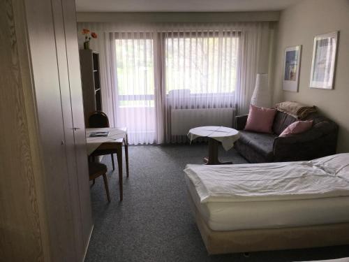 Habitación con cama, sofá y mesa. en Hotel Quellenhof Bad Urach, en Bad Urach
