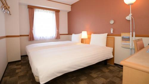 Postel nebo postele na pokoji v ubytování Toyoko Inn Sendai Higashi-guchi No.1