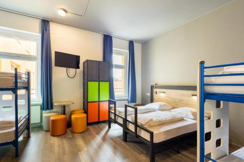 a bedroom with two bunk beds and a tv at a&o Dortmund Hauptbahnhof in Dortmund