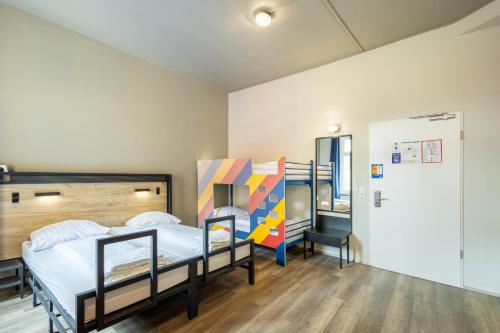 a bedroom with two bunk beds and a refrigerator at a&o Dortmund Hauptbahnhof in Dortmund