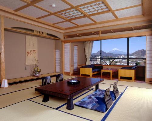 a living room with a wooden table and chairs at New Hakkeien in Izunokuni