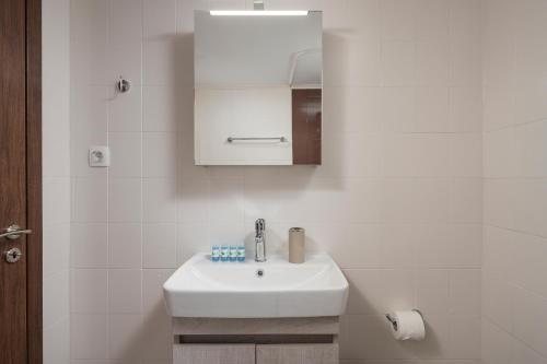 bagno bianco con lavandino e specchio di Sofias Dreamy Retreat a Katokhórion