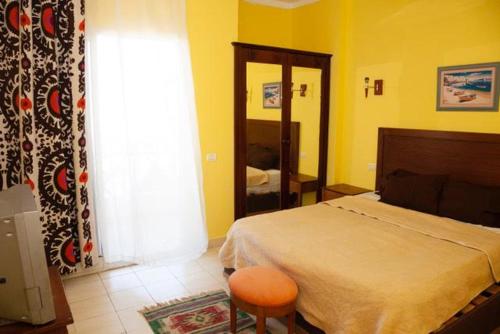 ein Schlafzimmer mit einem Bett, einem Stuhl und einem Fenster in der Unterkunft Apartment Sharm in Sharm El Sheikh