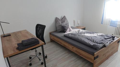 a bedroom with a bed and a desk with a chair at Apartment Ferienwohnung Vogt in Sinzheim