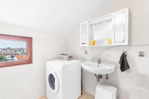 a white bathroom with a washing machine and a sink at Apartment Luna in Poreč