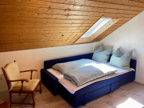 um quarto com uma cama azul e uma clarabóia em Haus Hanni em Höchenschwand