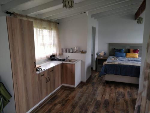 a kitchen with a sink and a bed in a room at The Little Cove in Vaal Marina