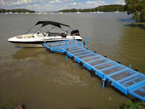 a boat is docked at a dock in the water at The Little Cove in Vaal Marina