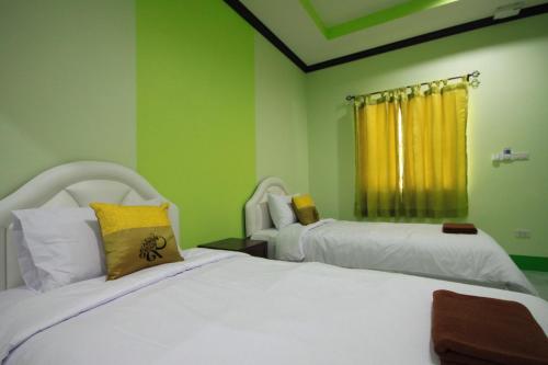 2 camas en una habitación con paredes verdes en Bangburd Resort, en Ban Khiam En