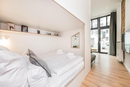 a white bedroom with a large bed with white sheets at Stylish New Cube Loft II by Berlin-Wall-Apartments in Berlin