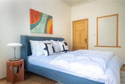 um quarto com uma cama azul e almofadas brancas em MINIQ HOMES 104 - The Luxurious Stone Retreat em Foça