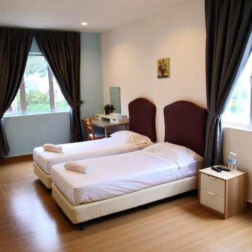 two beds in a room with two windows at Dear Dino Villa Cameron Highlands in Cameron Highlands