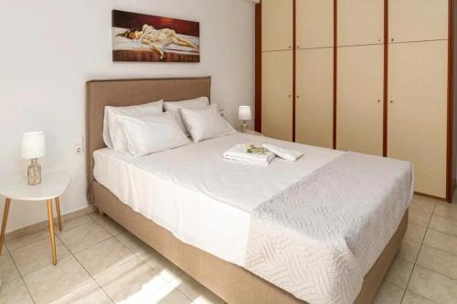 Un dormitorio con una gran cama blanca y una mesa en ENASTRON HOME WITH SEA VIEW, en Palaiokastro