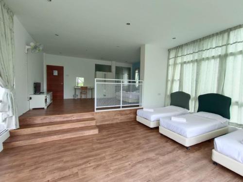 a living room with two white beds and wooden floors at Dear Dino Villa Cameron Highlands in Cameron Highlands
