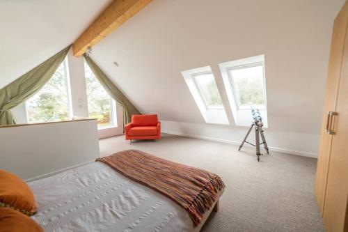 a bedroom with a bed and a red chair at Home from Home self catering for 2 in St Austell