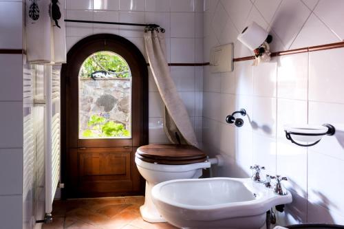 La salle de bains est pourvue de toilettes, d'un lavabo et d'une fenêtre. dans l'établissement La Moiana, à San Quirico dʼOrcia