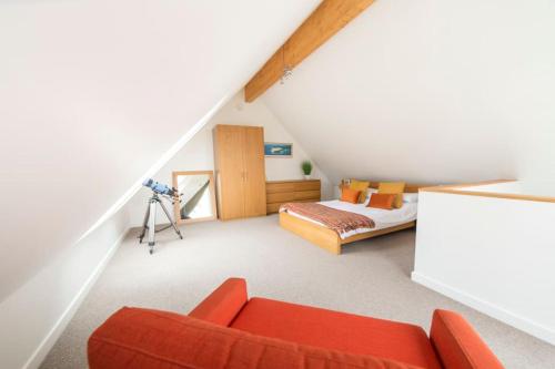 una camera mansardata con un divano rosso e un letto di Home from Home self catering for 2 a St Austell