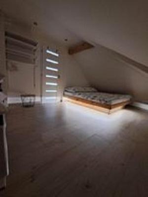 an attic room with a bed and a window at Apartman Barbara in Lipany