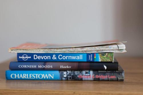 a stack of books sitting on a table at Home from Home self catering for 2 in St Austell