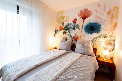 a bedroom with a bed with a flower mural on the wall at FESTWIESE - modernes Apartment nahe Neustadter Innenstadt in Neustadt an der Weinstraße