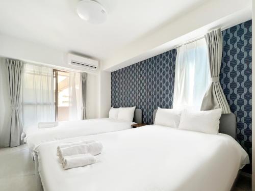 a hotel room with two beds and a window at Dio Higashi Shinsaibashi in Osaka