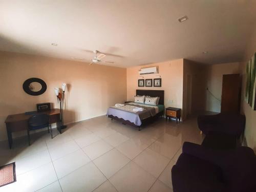 a bedroom with a bed and a desk in a room at Le Uaina Beach Resort in Falepuna